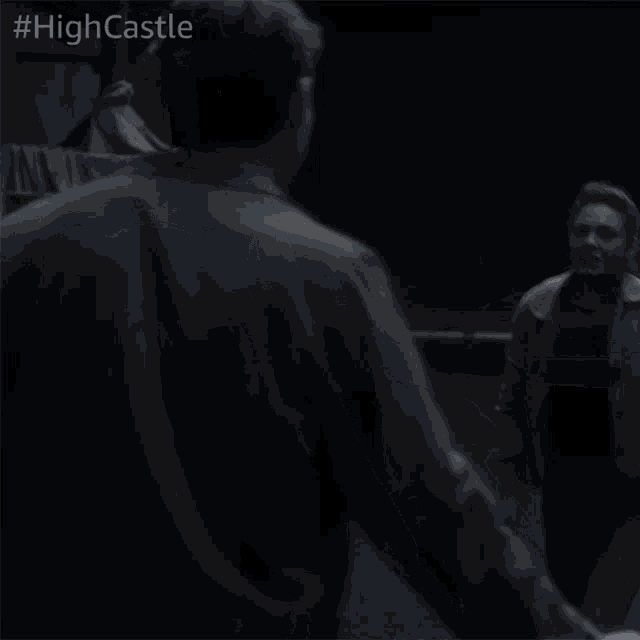 a man and a woman are fighting in a dark room with #highcastle written on the bottom right