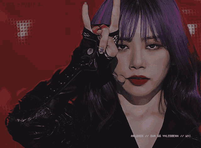 a woman with purple hair is making a devil horns sign