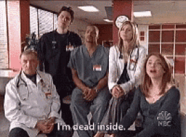 a group of doctors and nurses are sitting in a hospital room .