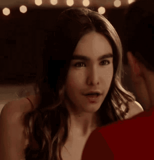 a man and a woman are looking at each other and the woman is wearing a red top