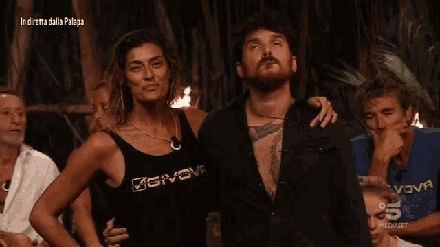a woman wearing a givova tank top stands with a man
