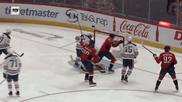a hockey game is being played on a rink with coca-cola advertisements