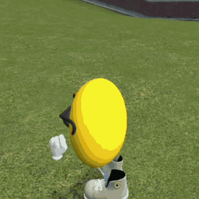 a yellow smiley face wearing sunglasses is standing on a grassy field .