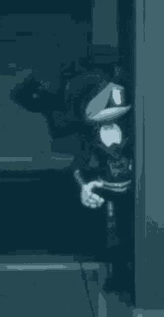 a robot is standing in a dark room holding a gun .