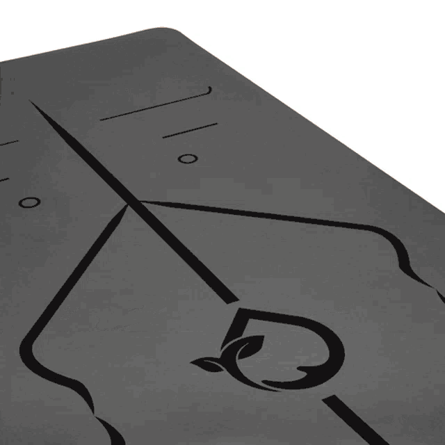 a black yoga mat with a drawing of a tree and leaves on it