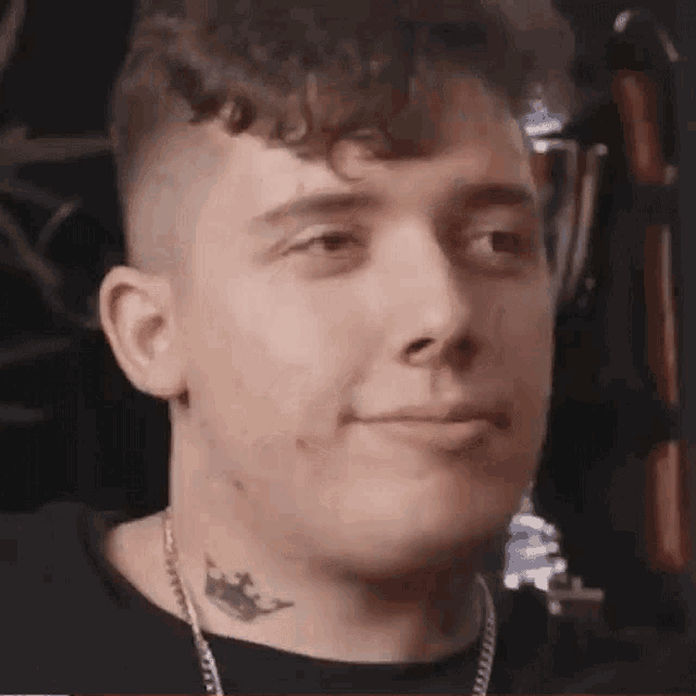 a close up of a man with a tattoo on his neck .