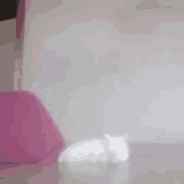 a person is laying on a bed with a pink blanket on it .