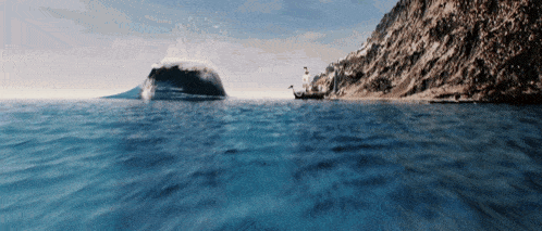 a boat is in the middle of the ocean with a large rock in the background