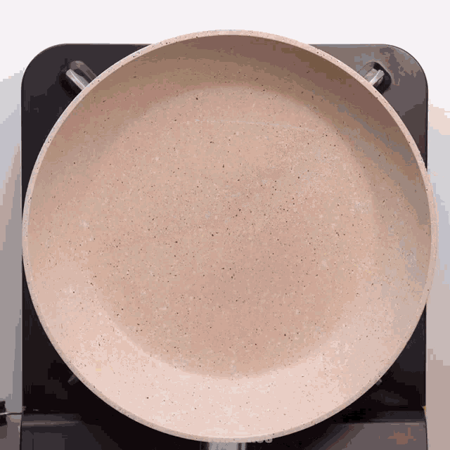 a frying pan is sitting on top of a black stove top