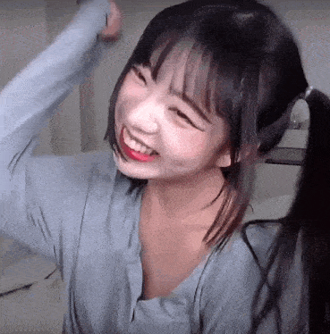 a girl with pigtails is smiling and looking at the camera .