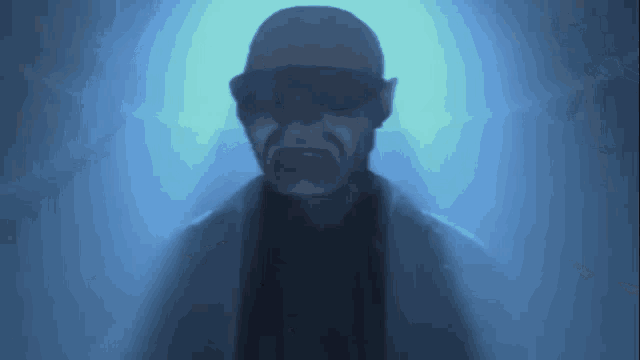 a man wearing sunglasses and a hat is standing in a foggy room