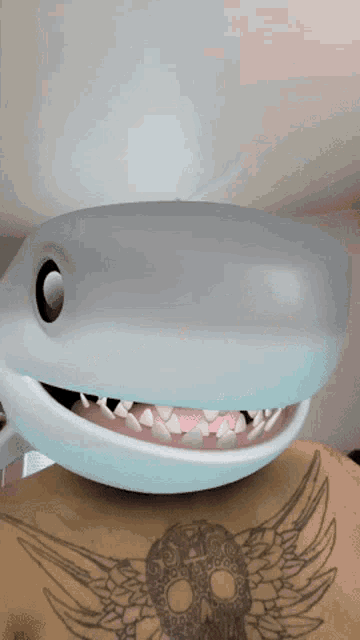 a person with a tattoo on their back has a shark mask on