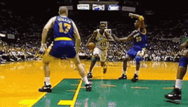 a group of basketball players are playing a game of basketball .