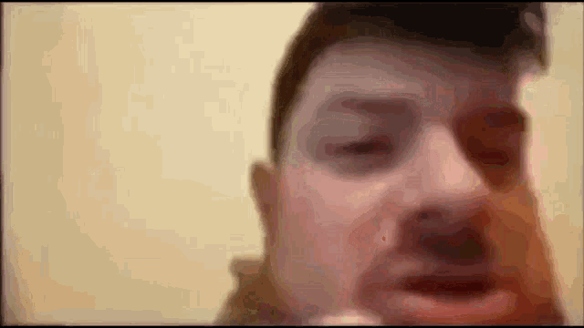 a close up of a man 's face with his eyes closed and his mouth open .