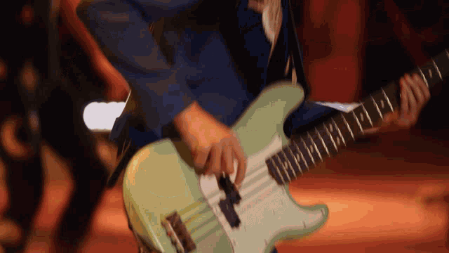 a man in a suit is playing a guitar