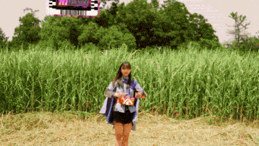 a girl is standing in a field with a sign in the background that says ' mvm '
