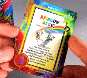 a person holding a card that says rainbow magic on it