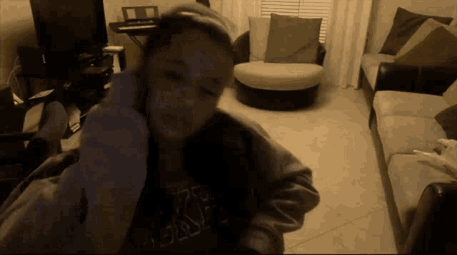 a girl wearing a shirt that says ' abercrombie & fitch ' on it is sitting in a living room
