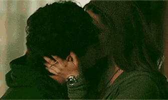 a man and woman are kissing in a dark room