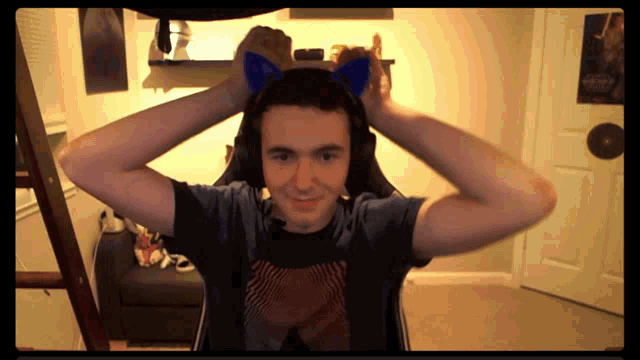 a man wearing cat ears and headphones looks at the camera