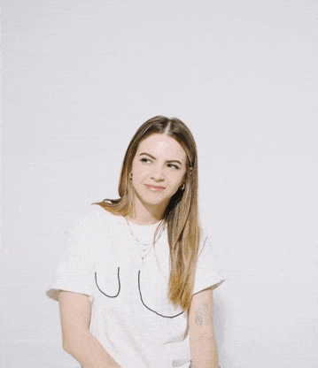 a woman is wearing a white t-shirt with a drawing of a breast on it