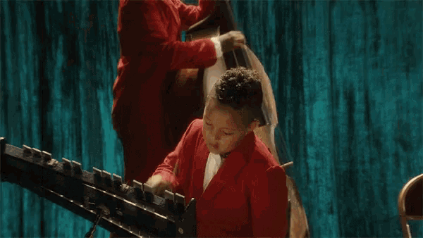 a man is playing a double bass and a woman is playing a piano