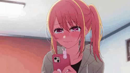 a pink haired anime girl is crying while looking at her phone .