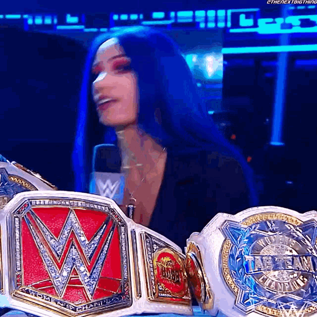 a woman with blue hair is holding a wwe belt