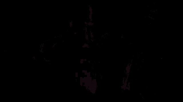 a monster with a skull on his face is holding a sword in a dark room .