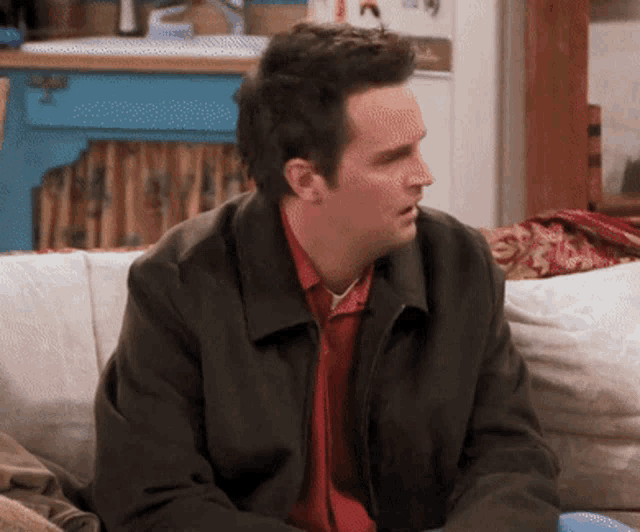 a man is sitting on a couch with his mouth open