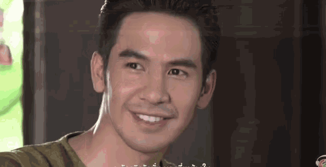 a man is smiling and looking at the camera while wearing a green shirt .