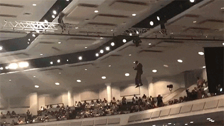 a man is hanging from the ceiling of a building