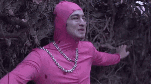a man in a pink costume with a chain around his neck .
