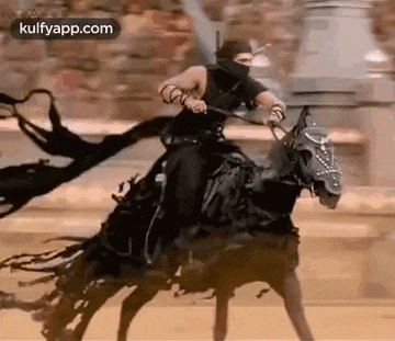 a man is riding a black horse with a sword in his hand .