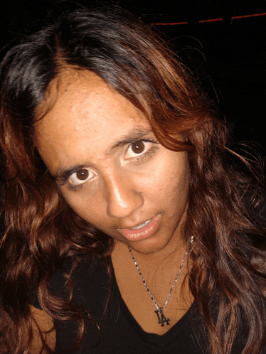 a woman wearing a necklace with the letter la on it