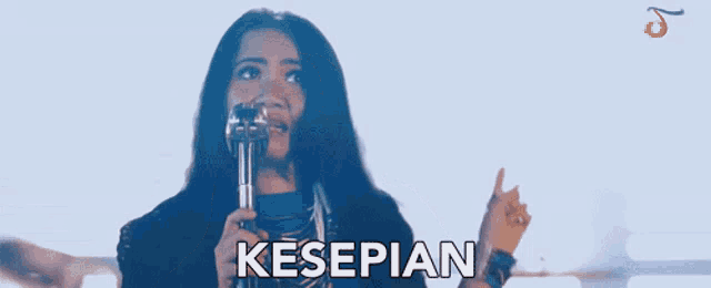a woman singing into a microphone with the word kesepian in white letters