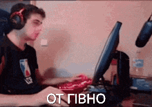 a man wearing headphones is sitting at a desk in front of a computer monitor .