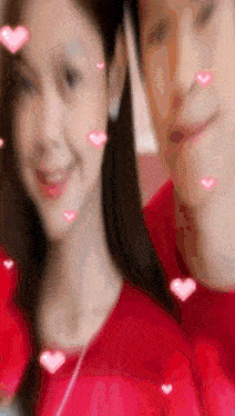 a man and a woman are standing next to each other with pink hearts coming out of their faces