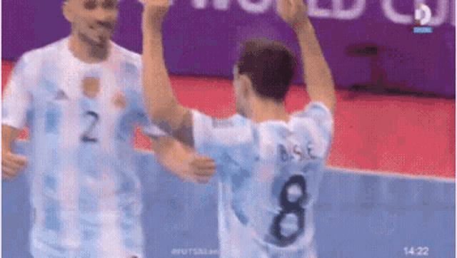 a soccer player with the number 8 on his back is being hugged by another player