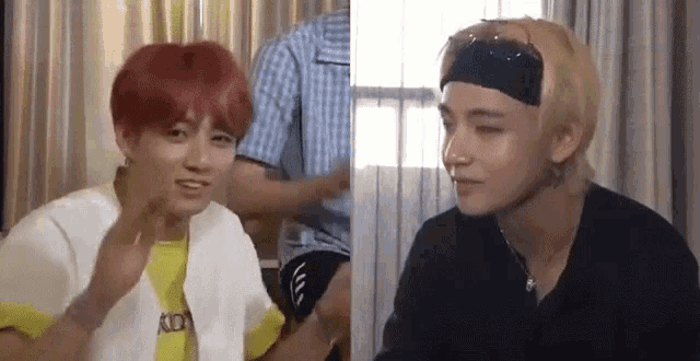 a couple of men are sitting next to each other in a room . one of the men has red hair and the other has blonde hair .