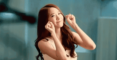 a young woman is making a heart shape with her hands .