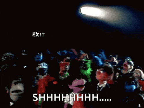 a group of puppets are standing in front of a exit sign
