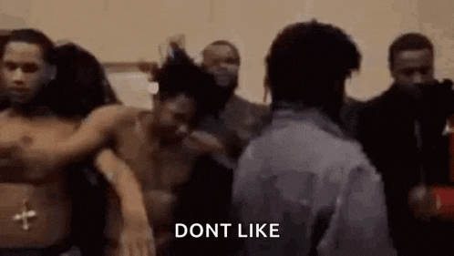a man is standing in front of a group of people without shirts .