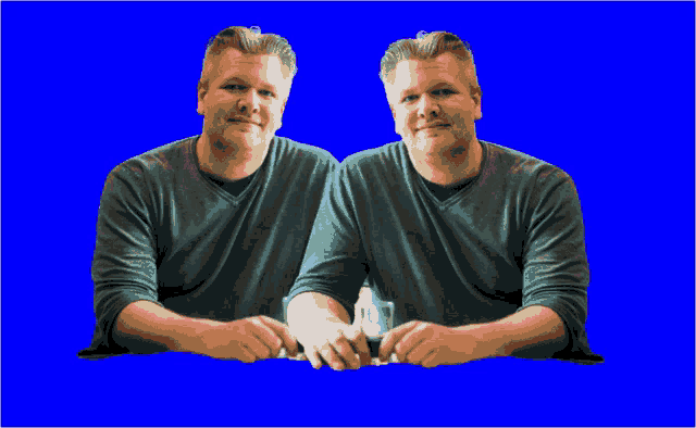 two men are sitting next to each other with their hands on a table