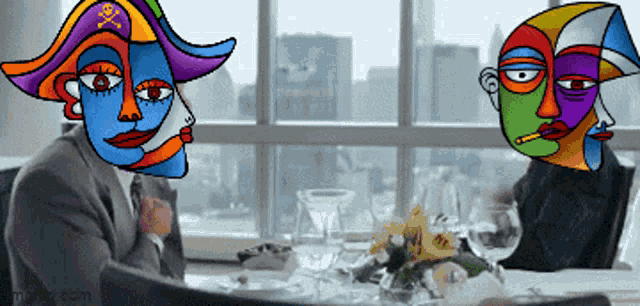 a man in a suit sits at a table with two colorful faces on his head