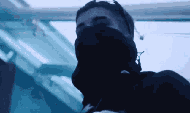 a man wearing a mask and headphones is looking at the camera