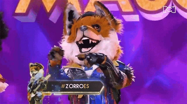 a fox is standing on a stage in front of a sign that says zorroes