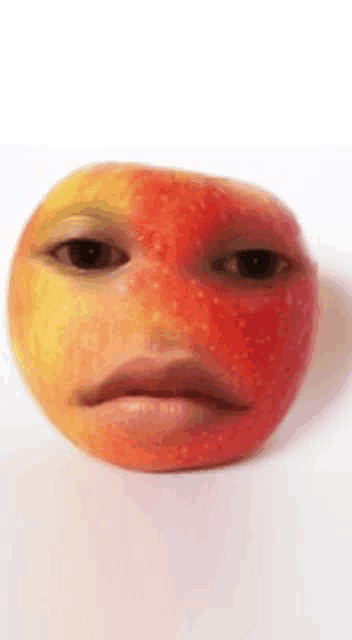 a close up of an apple with a face on it on a white background .