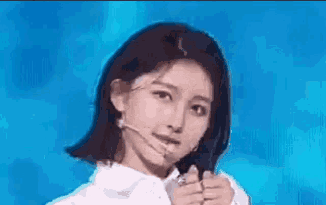 a close up of a woman wearing a microphone and a white shirt on a stage .