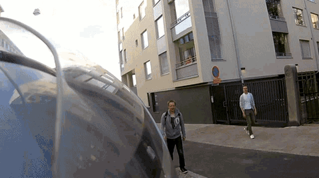 a man wearing a sweatshirt that says ' lg ' on it walks down the street